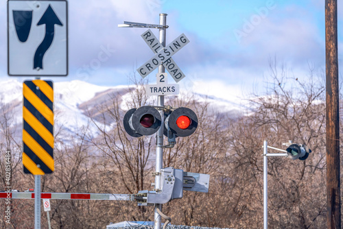 Grade crossing signal with red light gate and crossbuck at railroad crossing