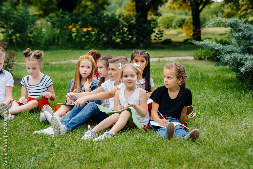 A teacher teaches a class of children in an outdoor Park. Back to school, learning during the pandemic A teacher teaches a class of children in an outdoor Park. Back to school, learning during the pandemic