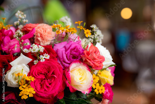 Colorful roses in rose flower bouquet with bokeh background.
