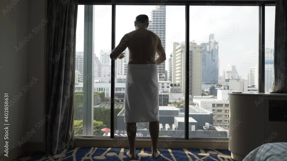 Man spray deodorant on armpit by window at home Man spray deodorant on armpit by window at home