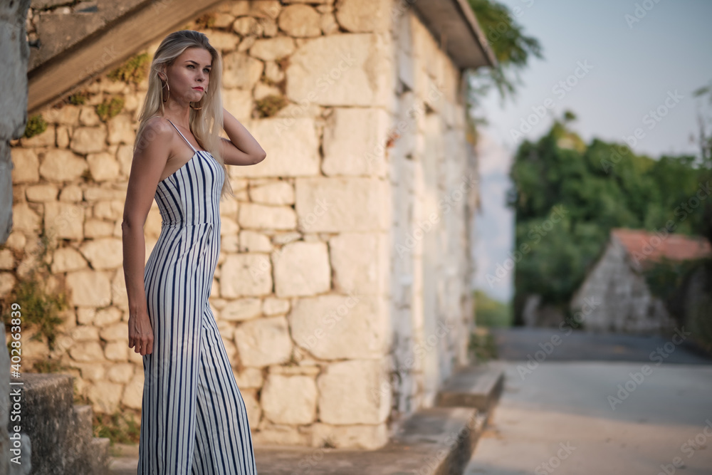Traveling by Europe. Happy young woman in elegant dress walking by streets , Croatia.