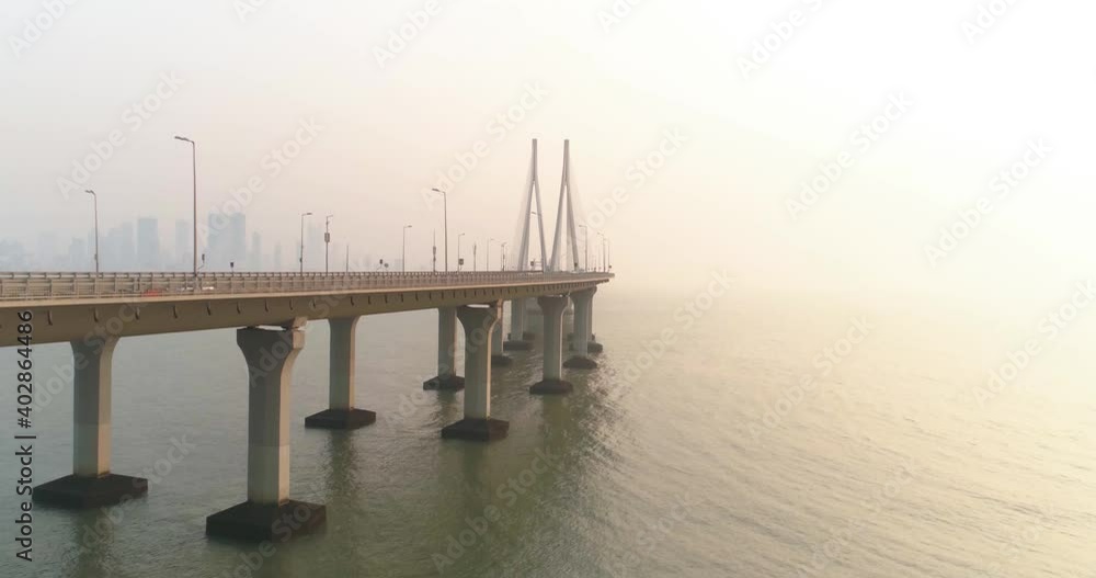A drone shot at Bandra Worli Sea Link seen from an aerial view in slow motion. Cinematic drone movement with the iconic Mumbai Sea Link at the forefront and the city view in the background. A drone shot at Bandra Worli Sea Link seen from an aerial view in slow motion. Cinematic drone movement with the iconic Mumbai Sea Link at the forefront and the city view in the background.