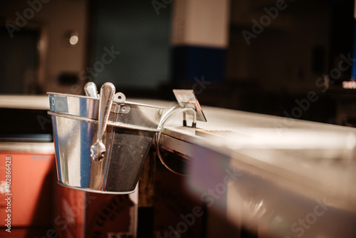 Cubo de acero inoxidable con pinzas para cubos de hielo en la barra de un bar photo