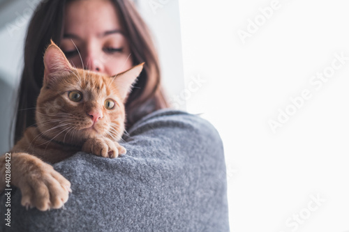 Pretty woman holding and looking at a cat
