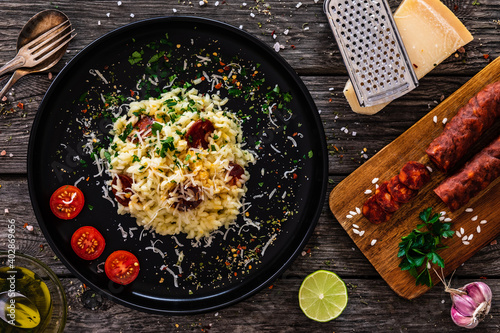 Risotto with parmesan and chorizo on wooden background 