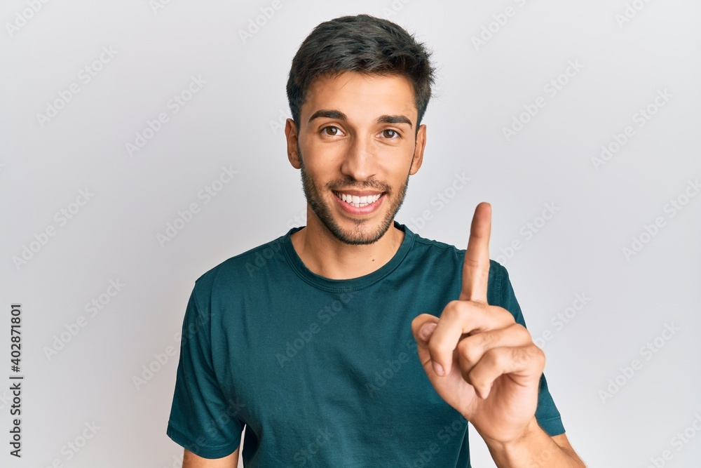 Young handsome man wearing casual clothes smiling with an idea or question pointing finger up with happy face, number one Young handsome man wearing casual clothes smiling with an idea or question pointing finger up with happy face, number one