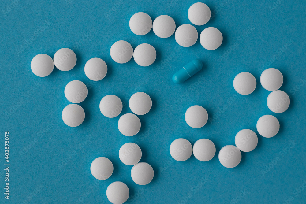 The pill sign points to the heart on a blue background. Medical concept 