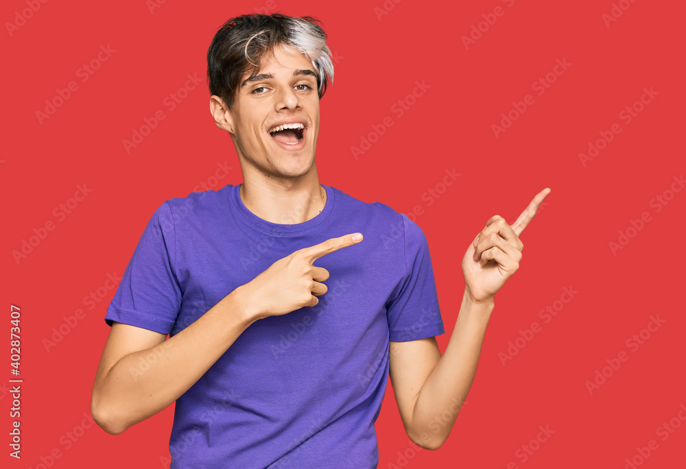 Young hispanic man wearing casual clothes smiling and looking at the camera pointing with two hands and fingers to the side. Young hispanic man wearing casual clothes smiling and looking at the camera pointing with two hands and fingers to the side.