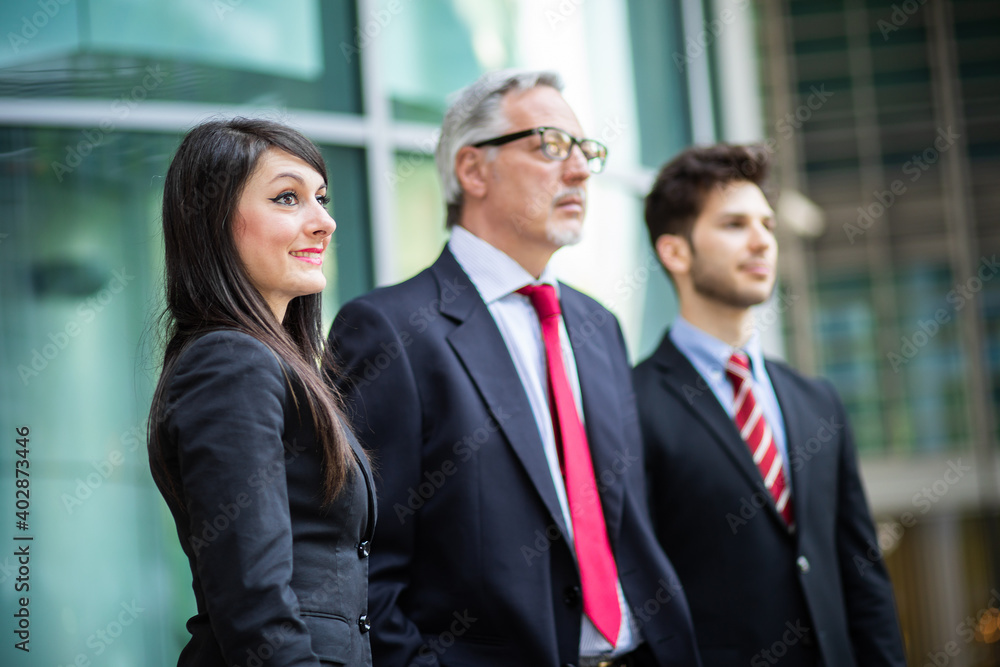 Business team smiling outdoor in a modern urban setting looking forward Business team smiling outdoor in a modern urban setting looking forward