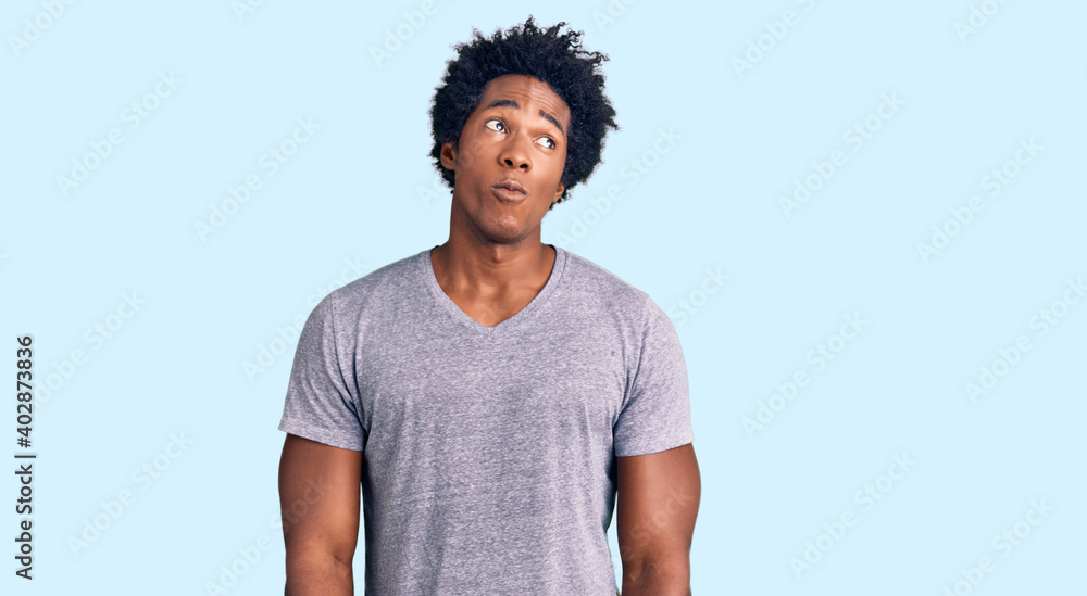 Handsome african american man with afro hair wearing casual clothes smiling looking to the side and staring away thinking. Handsome african american man with afro hair wearing casual clothes smiling looking to the side and staring away thinking.