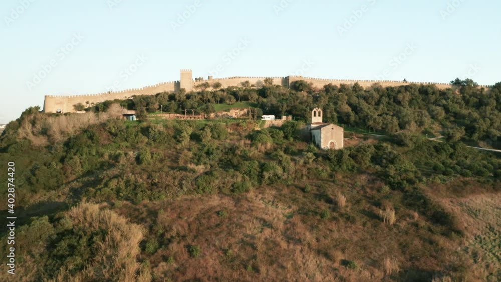 Revealing Shot Of Obidos Castle Behind Wall In Portugal With Ermida de Nossa Senhora do Carmo Chapel On Foreground - ascending drone, wide shot Revealing Shot Of Obidos Castle Behind Wall In Portugal With Ermida de Nossa Senhora do Carmo Chapel On Foreground - ascending drone, wide shot