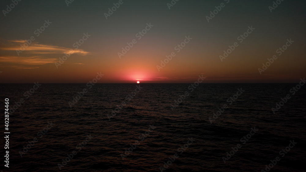 Atardecer y sus bellos colores en medio del Océano Pacífico, mostrando el momento exacto en el que el Sol se esconde por el horizonte.