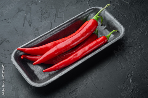 Ripe red chili peppers, on black background