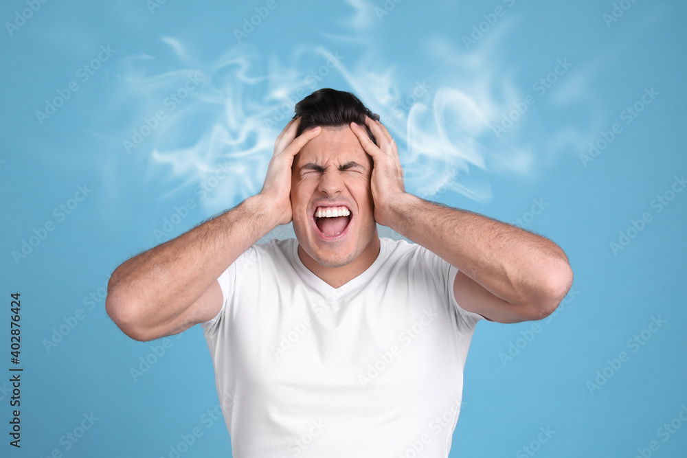 Stressed and upset young man on light blue background Stressed and upset young man on light blue background