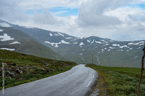 Pass road with snow fields on the side in the mountains of Norway