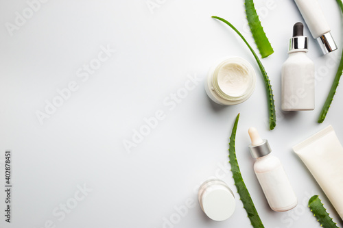 Aloe vera plant and Natural skincare beauty product. Cosmetic bottle and containers on white background
