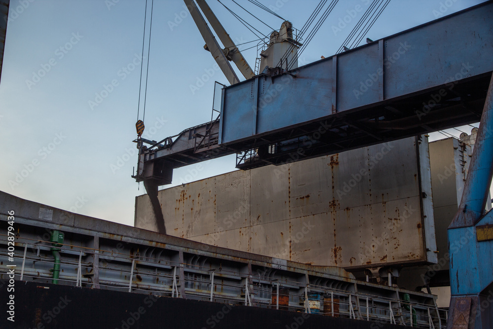 A shiploader loads a bulk cargo pellet into a ship's hold. A shiploader loads a bulk cargo pellet into a ship's hold.