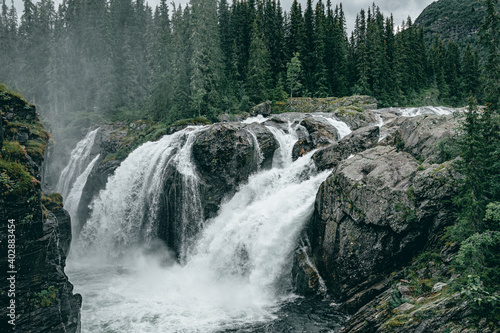 Rjukandefoss waterfall with dust and a rock