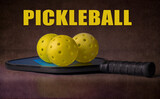 Pickleball paddle and balls. With the word 