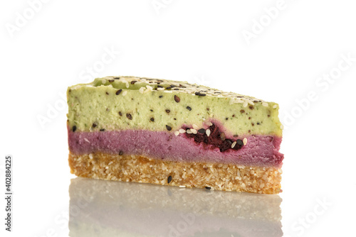 Piece of raw food cake with kiwi and bramble on a white plate.
