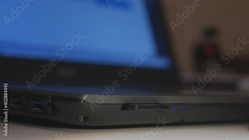 Wallpaper Mural Safely remove hardware. A man's hand extracts a SD card with information from a laptop. Torontodigital.ca