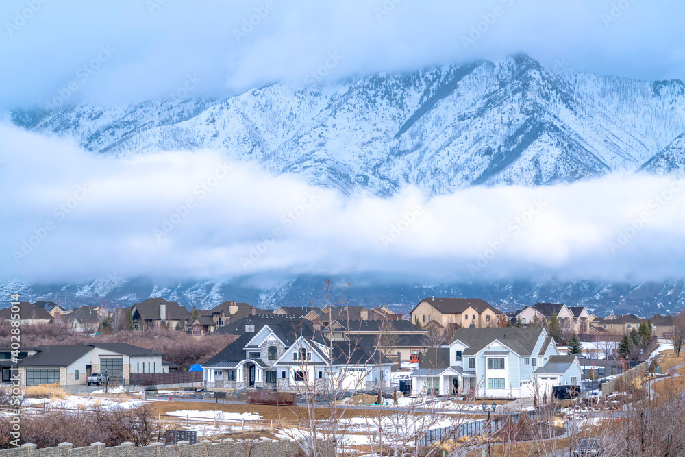Utah Valley community with towering Wasatch Mountain and dense clouds background