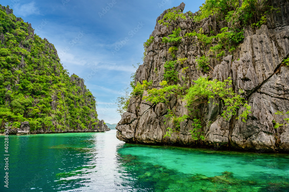Obraz premium Blue crystal water in paradise Bay with boats on the wooden pier at Kayangan Lake in Coron island, tropical travel destination - Palawan, Philippines.
