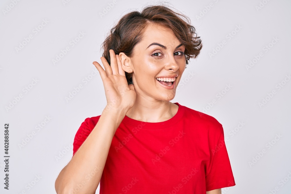 Young hispanic woman wearing casual clothes smiling with hand over ear listening and hearing to rumor or gossip. deafness concept. Young hispanic woman wearing casual clothes smiling with hand over ear listening and hearing to rumor or gossip. deafness concept.