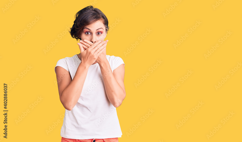 Beautiful young woman with short hair wearing casual clothes shocked covering mouth with hands for mistake. secret concept. Beautiful young woman with short hair wearing casual clothes shocked covering mouth with hands for mistake. secret concept.