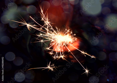  Burning sparkler in hands, close-up, bokeh-the concept of using lights for a bright environment during the holiday