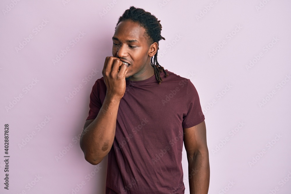 African american man with braids wearing casual clothes looking stressed and nervous with hands on mouth biting nails. anxiety problem. African american man with braids wearing casual clothes looking stressed and nervous with hands on mouth biting nails. anxiety problem.