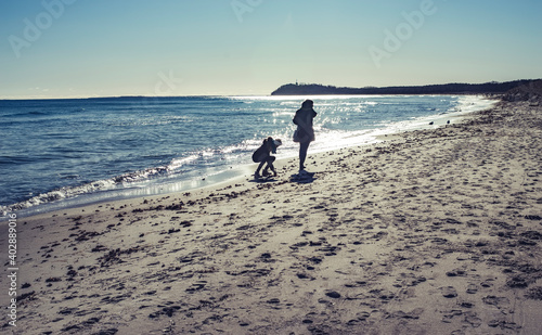 Mutter und Tochter spazieren am Strand