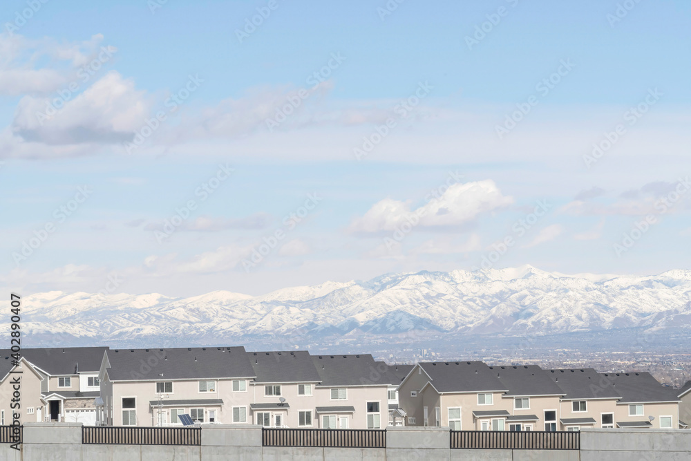 Houses against snowy mountain and scenic skyscape on a neighborhood landscape