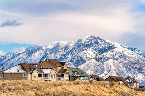 Homes with solar panels on roof against magnificent snowy Wasatch Mountain view © Jason