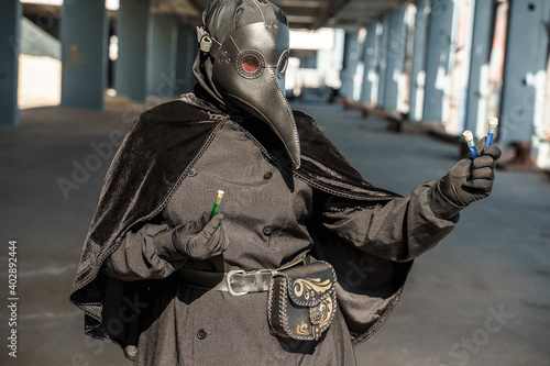 plague doctor in empty city on empty pier holds vaccine