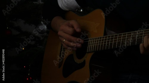 Young man playing acoustic guitar.