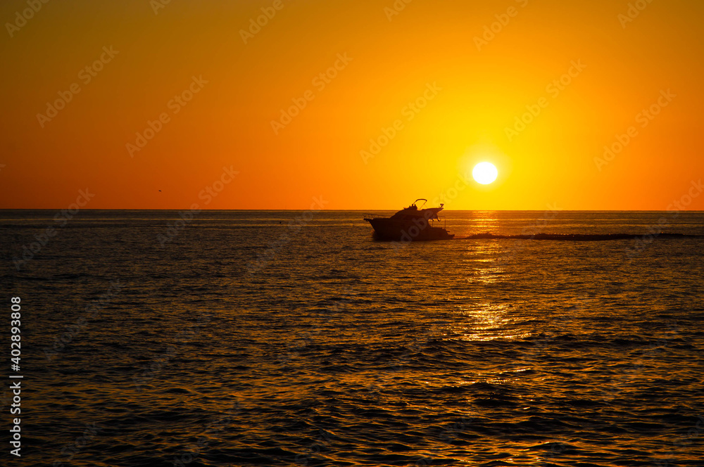 Silhouette of motor yacht on Mediterranean sea at sunset