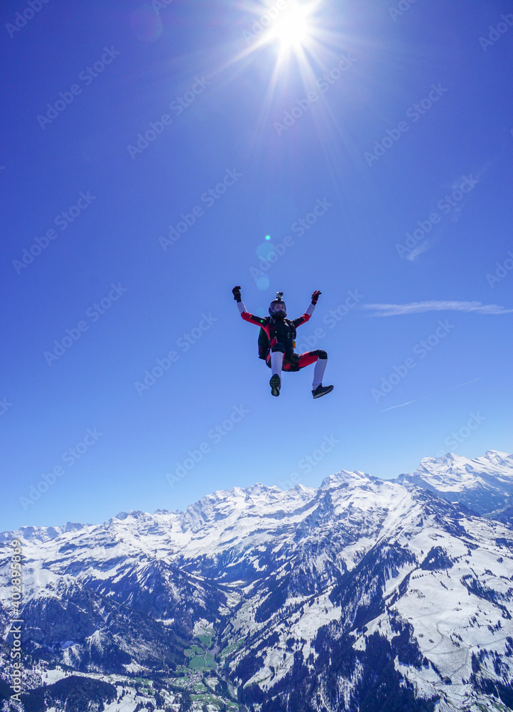 Skydiver performs stunts above snowcapped mountains Skydiver performs stunts above snowcapped mountains