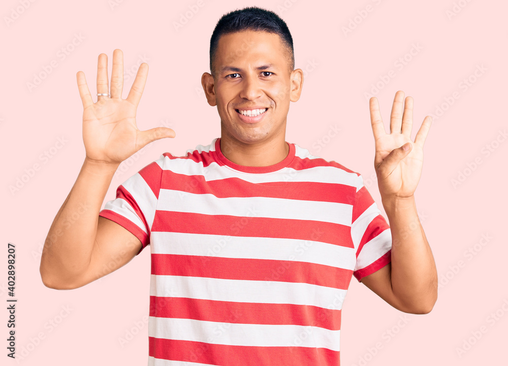 Young handsome latin man wearing casual clothes showing and pointing up with fingers number nine while smiling confident and happy. Young handsome latin man wearing casual clothes showing and pointing up with fingers number nine while smiling confident and happy.