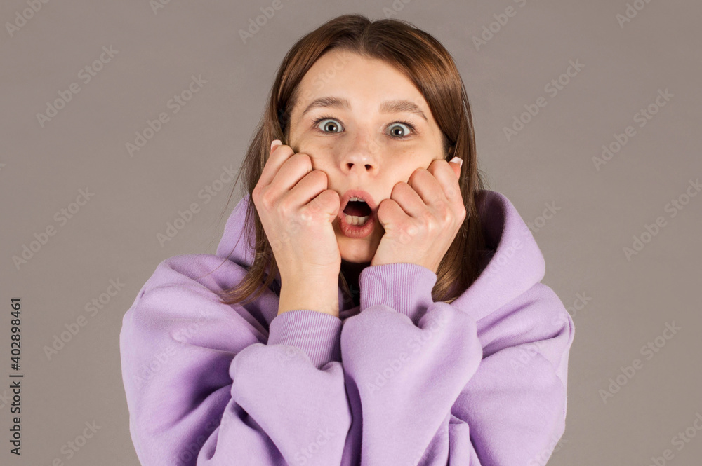 Amazed woman looking at camera isolated on a gray background Amazed woman looking at camera isolated on a gray background