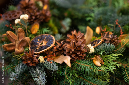 Christmas tree branch is decorated with cones, dried fruits © Natalia Nakonechna