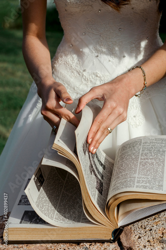 Hands of the bride, who turns the pages of a thick book