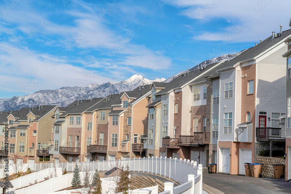 Townhouses on a winter residential landscape with snowy mountain peak background
