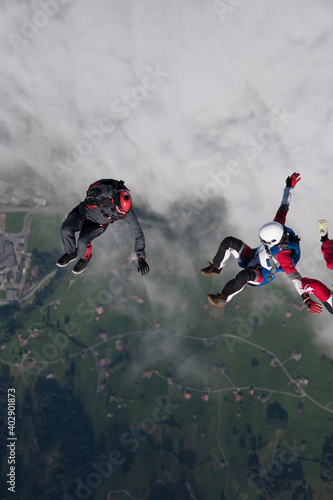 Freefall jumpers descend through lofty clouds