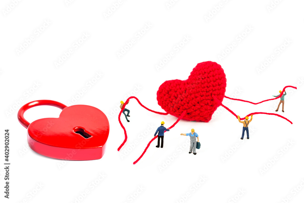 selective focus of miniature workers holding robe of heart and heart shape padlock on white background.