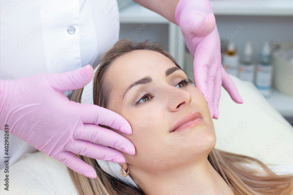 Naklejka premium cosmetology. Close up picture of lovely young woman receiving facial cleansing procedure