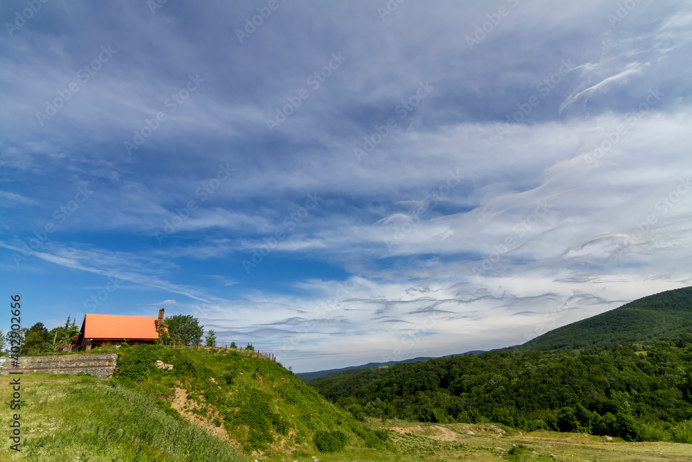 Different clouds in the blue sky and house of mountain