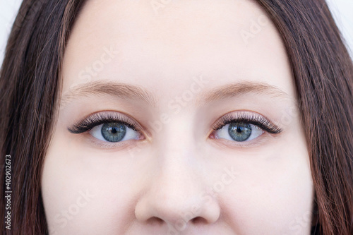 Eyelash extensions. Closeup of eyes with extended eyelashes and without extended eyelashes