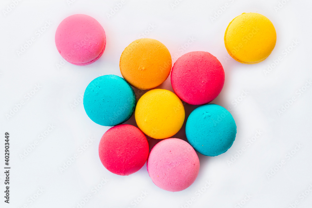 Multicolored macaroons standing on a blue plate on a wooden floor