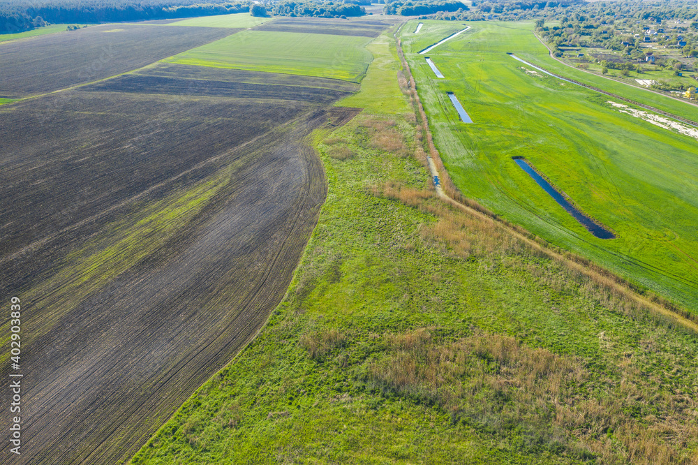 Land improvement or land amelioration concept, drone flying over narrow irrigation or drainage channels on rye or wheat field. Illustration of agriculture in the zone of risky agriculture